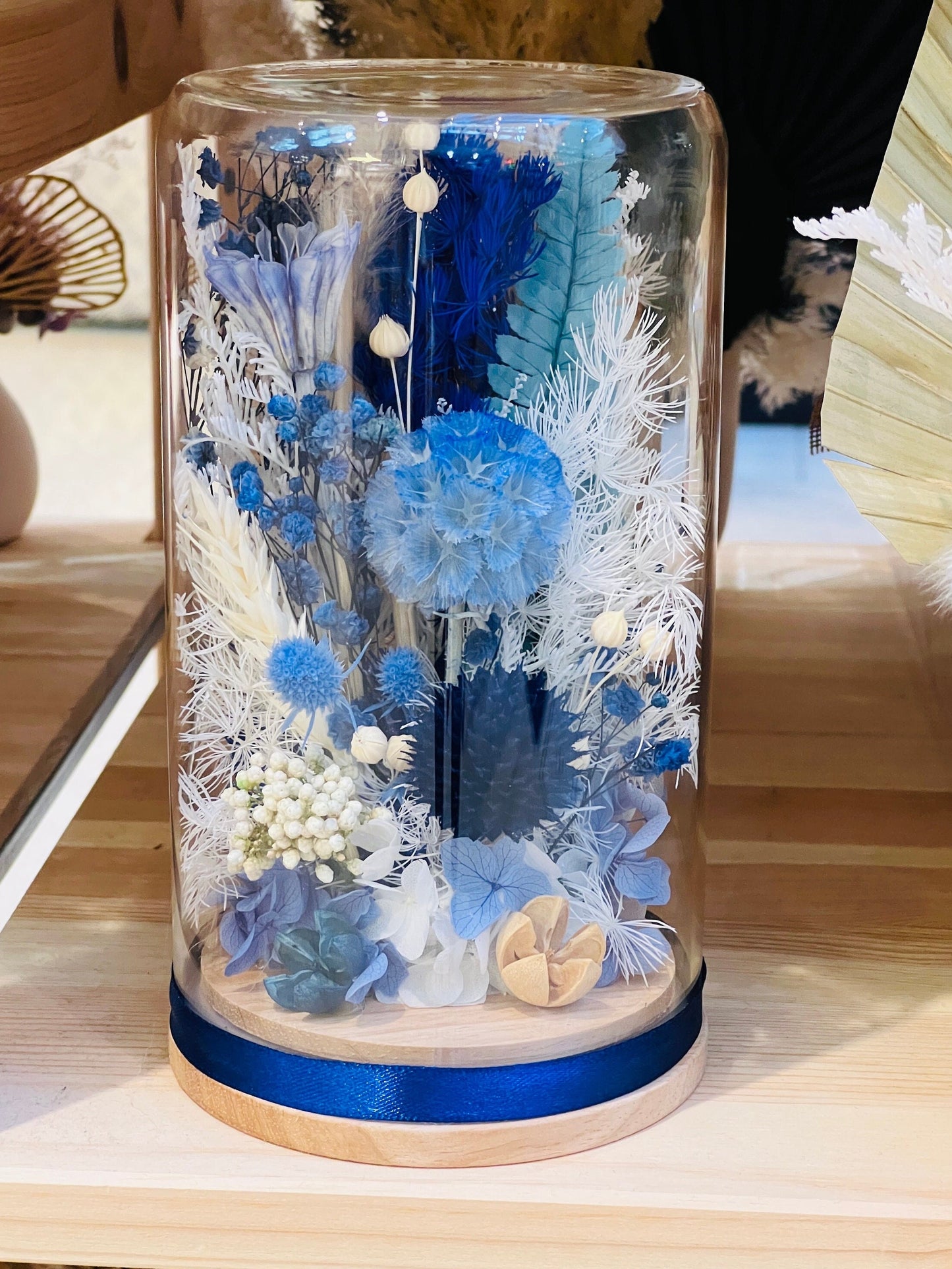 Discover the beauty of preserved flowers under a timeless blue glass dome. Showcase your favorite dried flowers in an everlasting arrangement that's perfect for any home decor or special occasion. Make a lasting impression with this elegant gift!