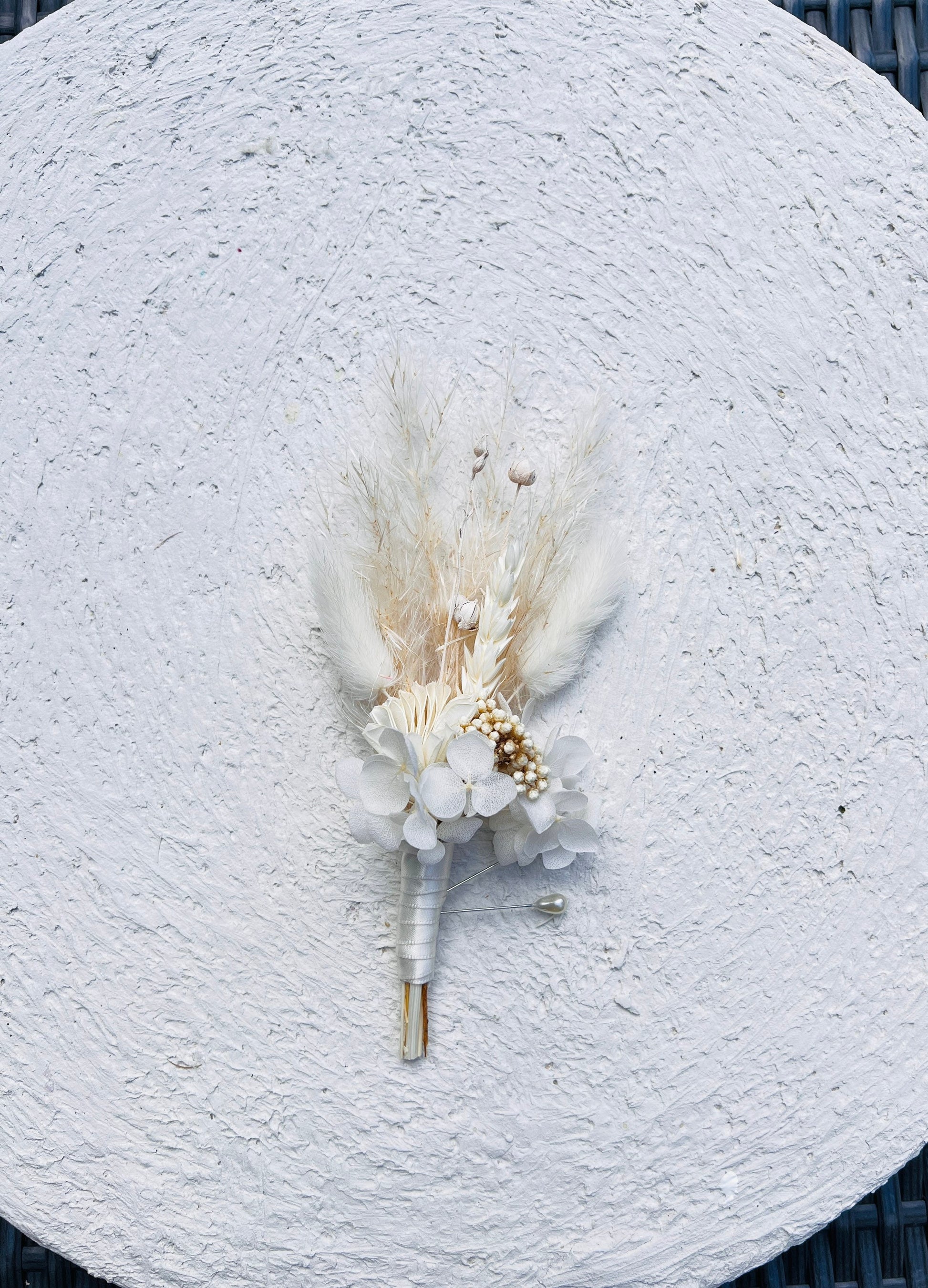 Complete your wedding look with this beautiful boutonnière. With dried flowers for a timeless look, it's easy to pin it onto the groom's jacket or pocket and will stand out in all of your wedding photos.

 